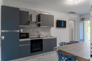 a kitchen with gray cabinets and a wooden table at Don Cesar Palace in Bibione