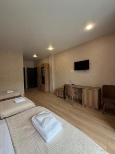 a bedroom with two beds and a flat screen tv at Hotel Sweet Night in Kazbegi