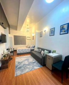 a living room with a couch and a bed at Kim's Cozy Place - Parthenon Residences in Cebu City