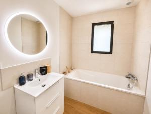 a white bathroom with a tub and a sink at Le Clos de Luc - 3 chambres - Jardin - Plage à 5 min in Luc-sur-Mer +21 photos