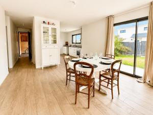 a kitchen and dining room with a table and chairs at Le Clos de Luc - 3 chambres - Jardin - Plage à 5 min in Luc-sur-Mer