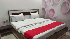 a bedroom with a large bed with a red blanket at Triveni Inn in Jahāngīrābād
