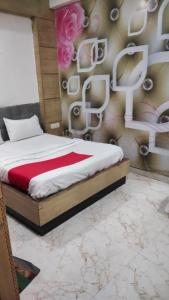 a bedroom with a bed with flowers on the wall at Triveni Inn in Jahāngīrābād