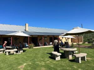 a group of benches and umbrellas in front of a restaurant at Lanseria Country Estate in Lanseria