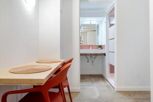 a small kitchen with a wooden table and red chairs at Port Apartsuite in Tarragona +26 photos