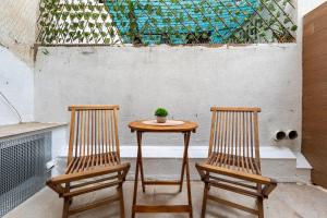 two chairs and a table with a potted plant on it at Port Apartsuite in Tarragona