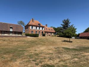 an old house with a large yard in front of it at Manoir de Cottentray Charming Manor in Avesnes-en-Bray