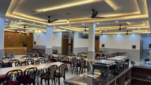 a banquet hall with tables and chairs in a room at Hotel The SunGod in Uttarkāshi