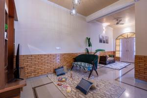 a living room with a chair and a brick wall at SaffronStays StoneVilla in Shimla