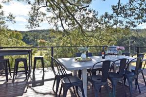 a table and chairs on a deck with a view at The Glass Ceiling 360 degree Mount View Hideaway in Mount View