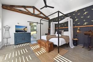 a bedroom with a canopy bed and a bathroom at The Glass Ceiling 360 degree Mount View Hideaway in Mount View +46 photos