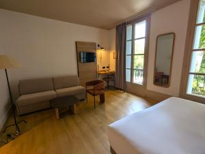 a bedroom with a bed and a couch and a table at Best Western Hotel Le Guilhem in Montpellier