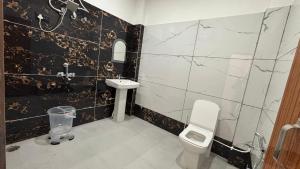 a bathroom with a toilet and a sink at Hotel The SunGod in Uttarkāshi +14 photos