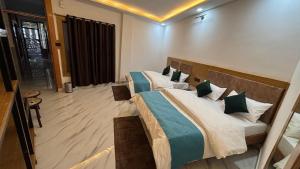 a bedroom with two beds in a room at Hotel The SunGod in Uttarkāshi