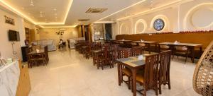 a restaurant with tables and chairs in a room at The Pearl Hotel Rampur in Rāmpur