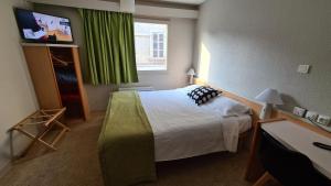 a hotel room with a bed and a window at Sweet Home in Belley
