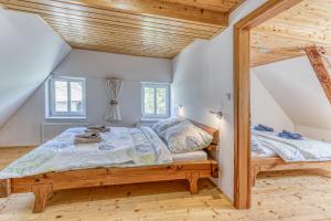 a bedroom with a bed and two windows at Roubenka Kailas in Červená Voda