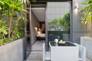 an outdoor patio with a table and chairs and plants at Oakwood Bencoolen Singapore in Singapore