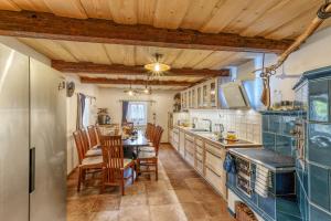 a kitchen with wooden ceilings and a table and chairs at Roubenka Kailas in Červená Voda