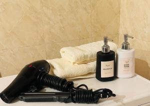 a black hair dryer sitting on a counter next to towels at Guest house Kyial in Naryn