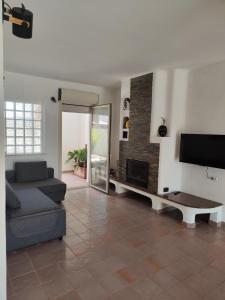 a living room with a couch and a tv at Oasi Villa Giusy in Capoterra