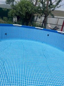 a blue tiled swimming pool in a yard at Sis Guest House in Tsʼoghamarg
