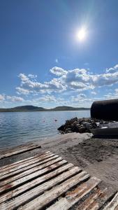 a beach with a boat on the water at Aurora Sea Lodges AURORAHUT in Herjenes