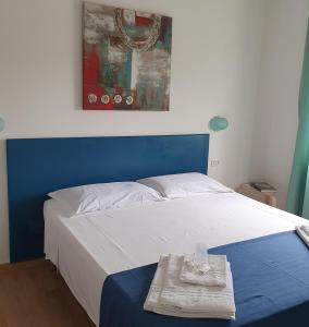 ein blau-weißes Bett mit einem Handtuch darauf in der Unterkunft Hotel Pixunte in Policastro Bussentino