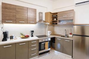 a kitchen with stainless steel appliances and wooden cabinets at Thea Stays in Kato Gouves +11 photos