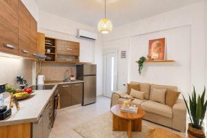 a kitchen and living room with a couch and a table at Thea Stays in Kato Gouves