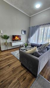 a living room with a couch and a fireplace at Pine View Guesthouse Graskop in Graskop
