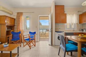 a kitchen with blue chairs and a table in it at Dimitra Apartments Zakros Village in Kato Zakros