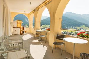 a room with chairs and tables and a view of mountains at Davos Youth Hostel in Davos