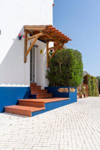 a house with a wooden door and stairs on it at Casa do Chafariz in Cercal