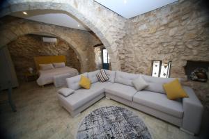 ein Wohnzimmer mit einem weißen Sofa in einer Steinwand in der Unterkunft Bmehrine The Inn in Byblos + 40 Fotos