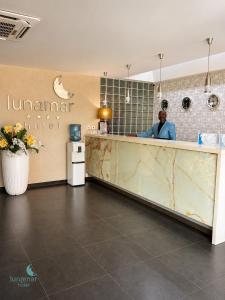 a man sitting at the counter of a hotel at Hotel Lunamar in Beira +30 photos