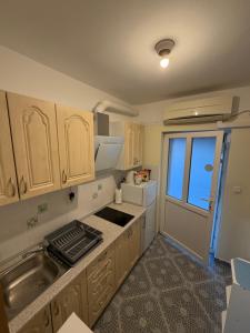 a kitchen with wooden cabinets and a sink and a window at Studio app Ana in Kostrena
