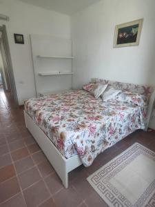 a bedroom with a bed with a floral comforter at Oasi Villa Giusy in Capoterra