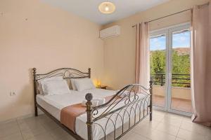 a bedroom with a bed and a balcony at Dimitra Apartments Zakros Village in Kato Zakros