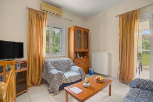 a living room with a chair and a tv at Dimitra Apartments Zakros Village in Kato Zakros