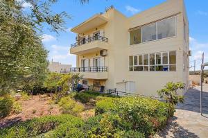 a large yellow house on top of a hill at Dimitra Apartments Zakros Village in Kato Zakros