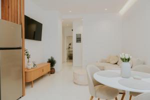 a white living room with a white table and chairs at Chez Jean in Argos
