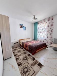 a bedroom with a bed and a rug at Jibek Murok in Bosteri
