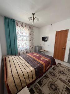 a bedroom with a bed and a window at Jibek Murok in Bosteri