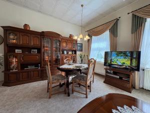 a dining room with a table and a television at Ferienwohnung Heidi in Annaberg-Buchholz