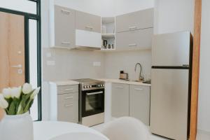 a kitchen with white cabinets and a white refrigerator at Chez Jean in Argos
