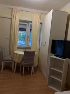 a dining room with a table and a television at Studio app Ana in Kostrena