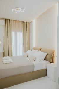 a bedroom with a bed with white sheets and a window at Chez Jean in Argos