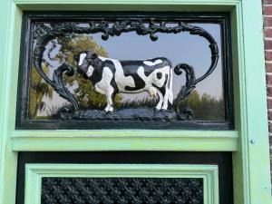 a glass door with a cow on top of it at De Noorderzon in Benningbroek