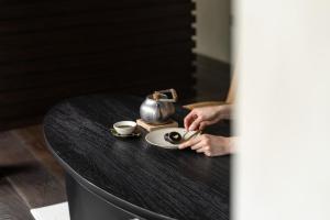 a person holding a cup of coffee on a table at 한옥스테이 서유재 in Ch'unch'ŏn-yŏk +13 photos